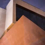 Low-angle shot of a modern building featuring geometric shapes and glass windows.